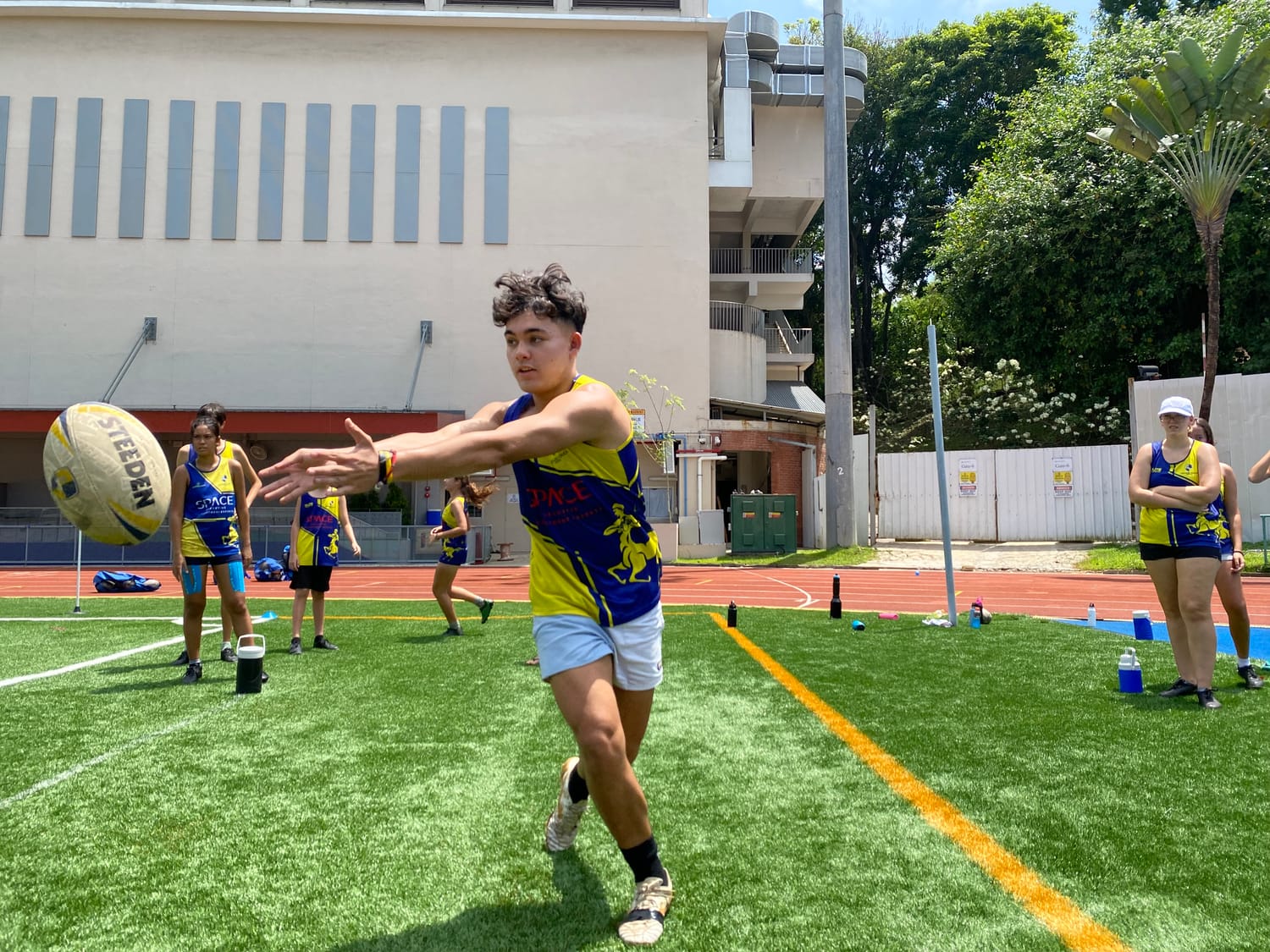 A Centaurs Touch player passes the ball across his body at a run during training